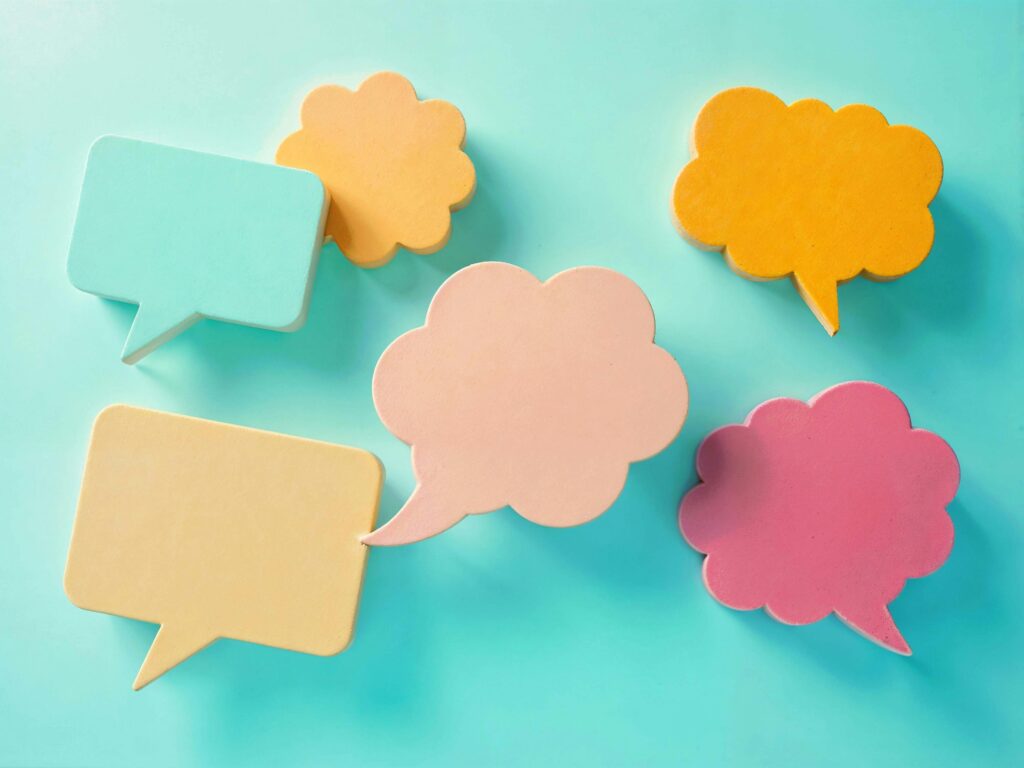 Bright pastel speech bubbles on a blue background, ideal for communication themes.